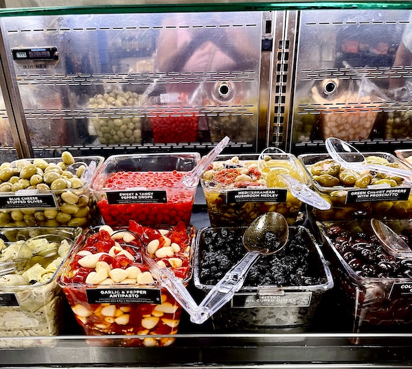 DeLallo Italian Marketplace olive bar with containers filled with olives, peppers and pickles
