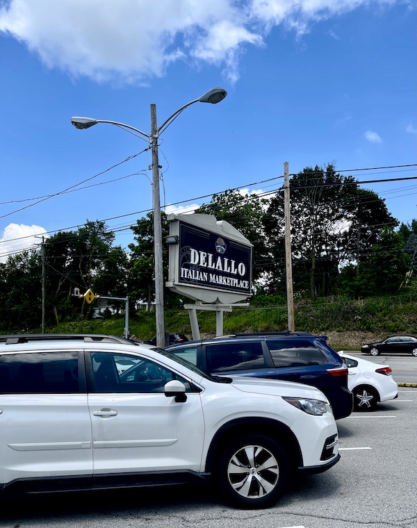 Parking lot with very large Black and white sign for DeLallo Italian Marketplace