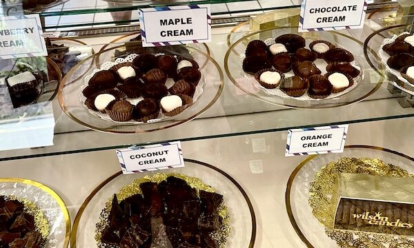 Plates of assorted cream filled chocolates in a glass display case at Wilson Candies Jeannette PA