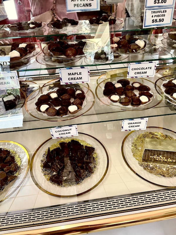 Plates of assorted cream filled chocolates in a glass display case at Wilson Candies Jeannette PA