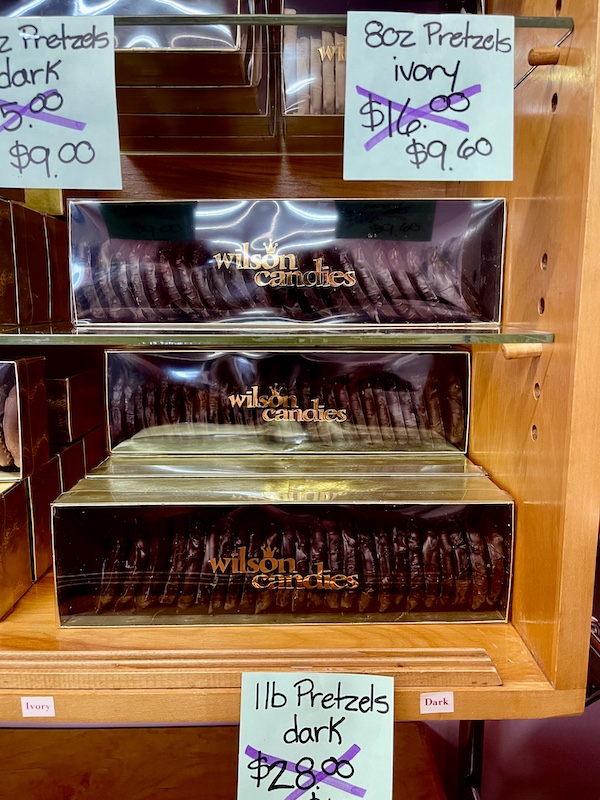 Display of boxes filled with dark chocolate covered pretzels with price card at Wilson Candies Jeannette PA