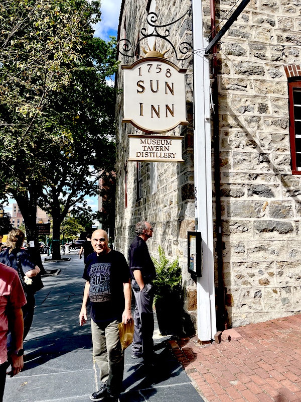 Steve standing by a sign for the Sun Inn museum, distillery and tavern est. 1758