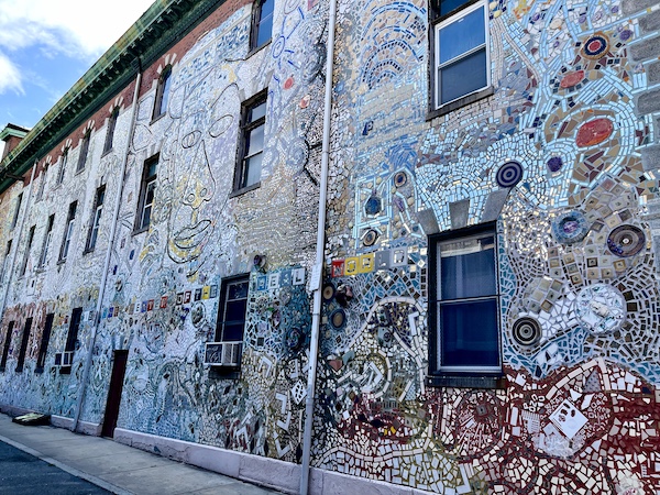 Entire side wall of a building covered in mirror and ceramic mosaic is part of the Murals Around Philadelphia