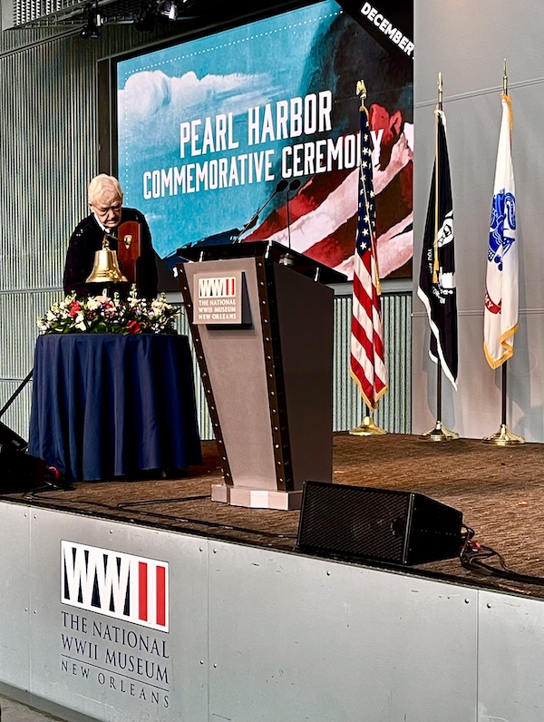 Elderly man ringing bell on stage at the WW2 Museum in New Orleans