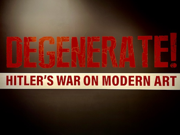 Sign on wall is Black red and white and announces the Degenerate! Hitler's War on Modern Art exhibit at the WW2 Museum