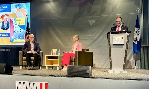 Two men and a woman on stage having a panel discussion at the WW2 Museum