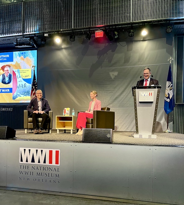 Two men and a woman on stage having a panel discussion at the WW2 Museum