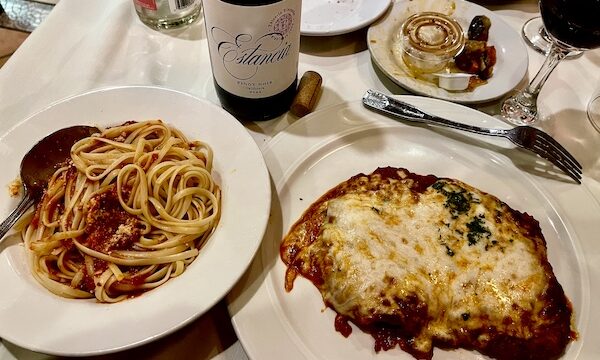 Two plates, one topped with linguine with red sauce and the other with veal parmesan at Sapore Woodfire Pizza and Restaurant