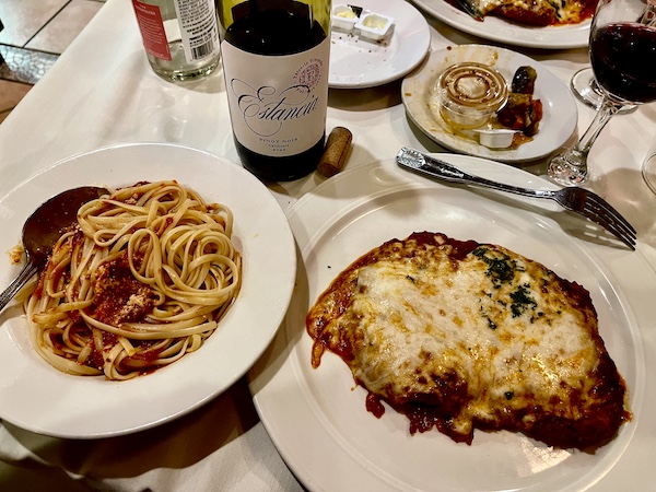 Two plates, one topped with linguine with red sauce and the other with veal parmesan at Sapore Woodfire Pizza and Restaurant