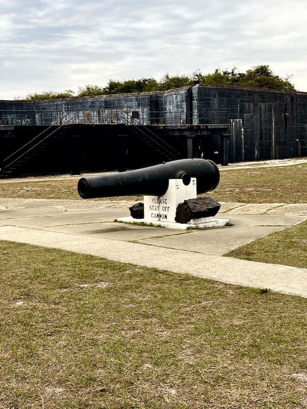 Cannon in center of fortress with black cannonballs stacked on sides at Fort Pickens Pensacola Florida