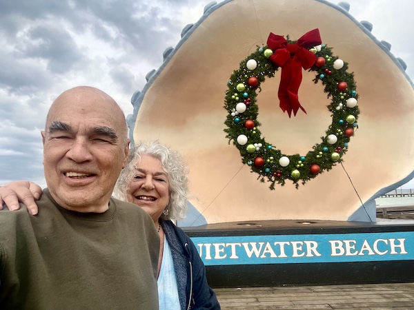 Steve and I taking a selfie in front of the giant seashell and Xmas wreathe at Pensacola Beach and Boardwalk