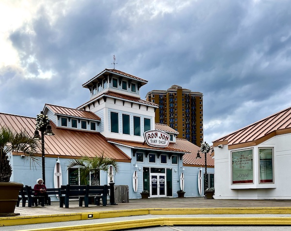 Large white building with terracotta barrel tile roof, on the Pensacola Boardwalk
