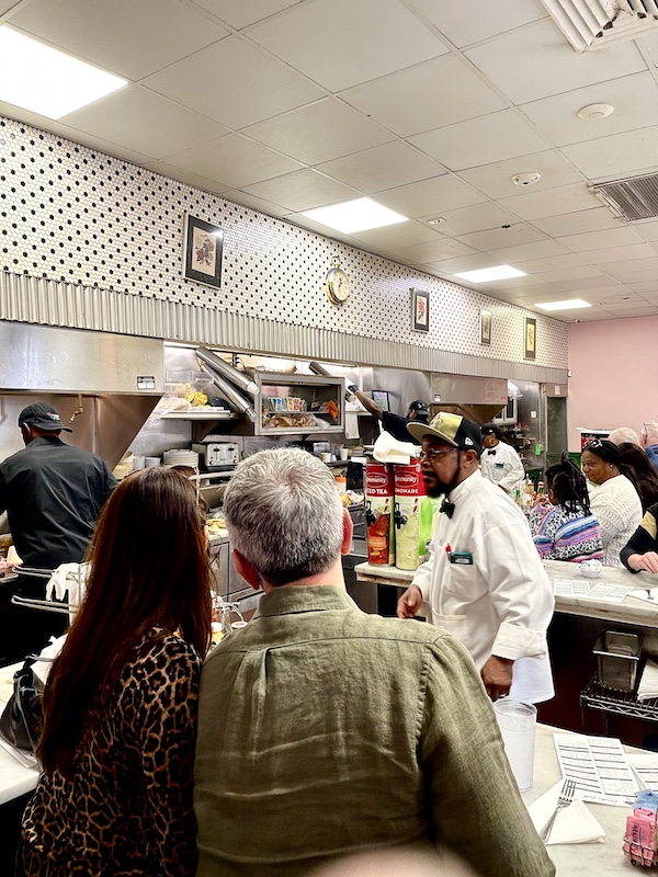 People dining at Camellia Grill New Orleans and cooks working in the open kitchen.