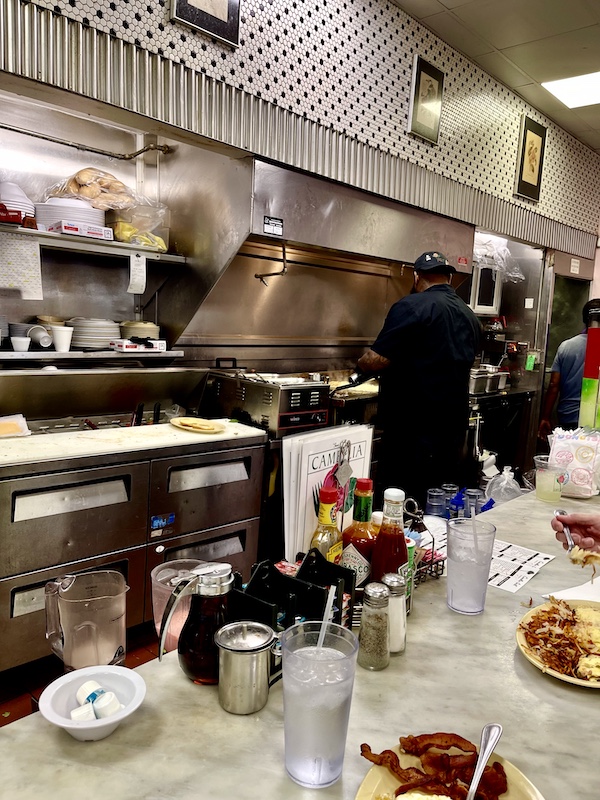 Chef cooking breakfast on the flattop at Camellia Grill New Orleans