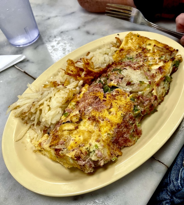 Omelette with ham, peppers and onions served alongside hash browns at Camellia Grill New Orleans