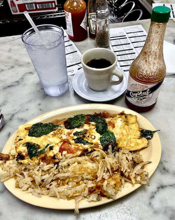 Omelette of tomato, spinach, onion and feta served with hash browns at Camellia Grill New Orleans