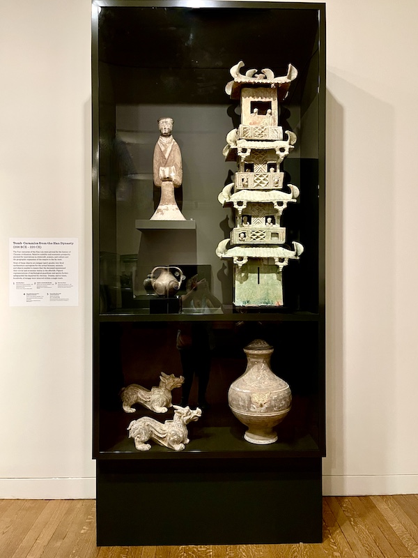 Assorted ceramic items from Han Dynasty tombs including a tall pagoda in a display case at the New Orleans Museum of Art