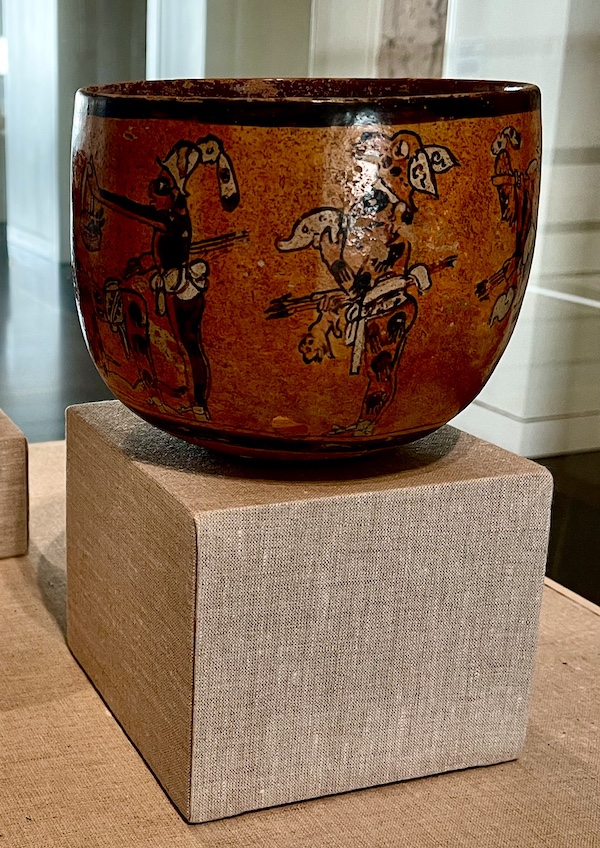 Red clay bowl painted showing ancient Mayan people doing their hunting ritual on display at the New Orleans Museum of Art