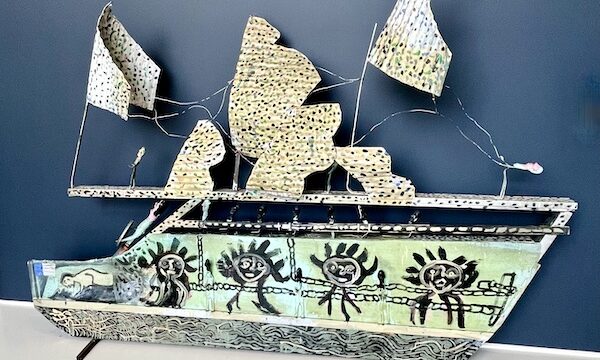 Sculptural art piece of a slave ship showing men with chains and colorful sails at the New Orleans Museum of Art