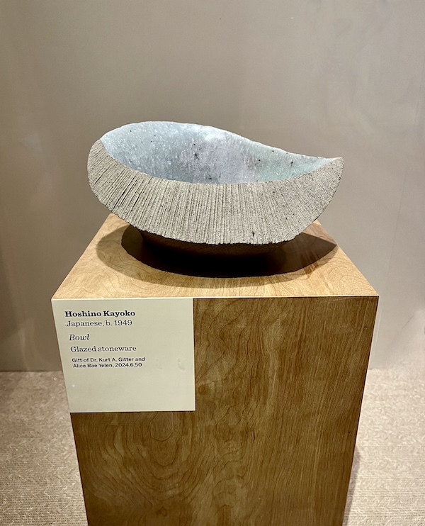 Gray stoneware bowl with smooth and ridged texture on a wood pedestal at the New Orleans Museum of Art