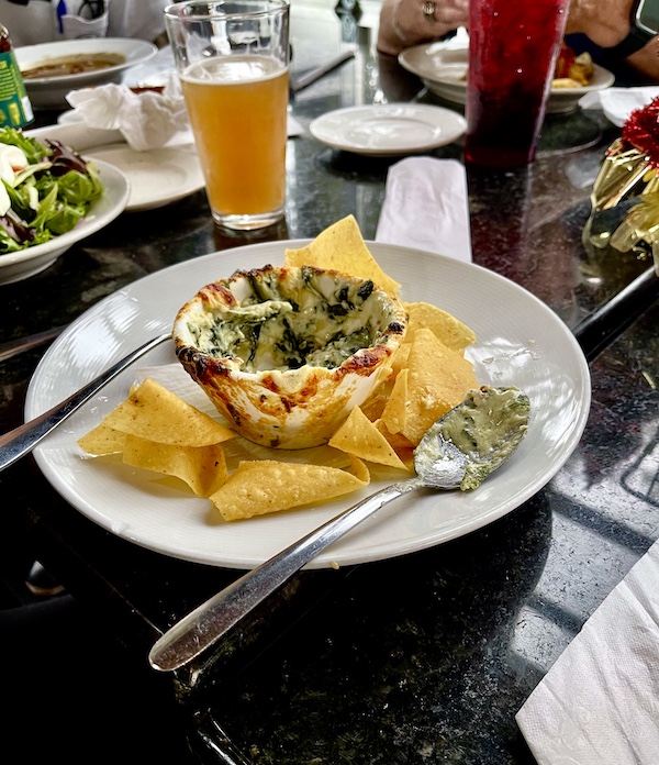 White bowl filled with spinach artichoke dip surrounded by tortilla chips at New Orleans RV Resort and Marina