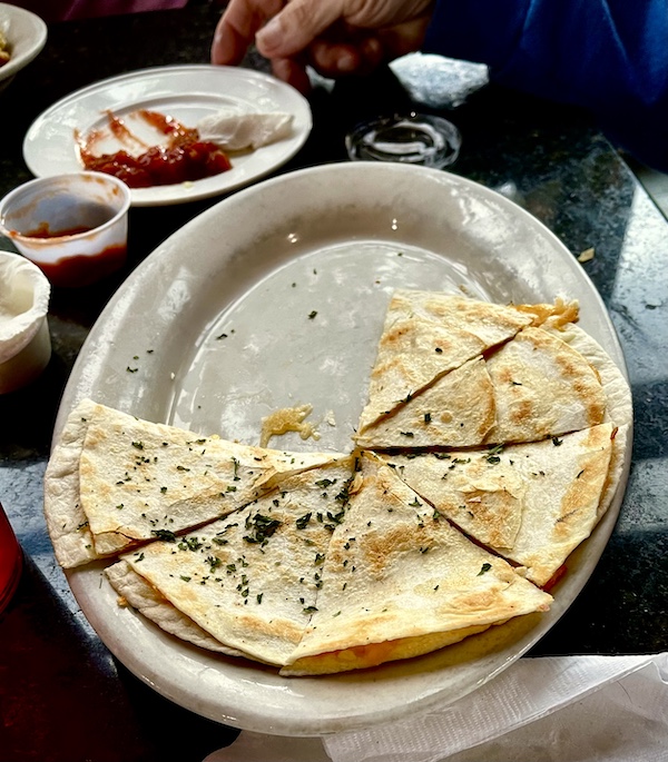 White platter topped with wedges of a quesadilla filled with chicken and cheese at New Orleans RV Resort and Marina