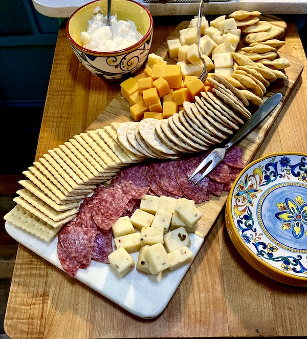 Wood and marble board topped with pieces of salami, crackers and cheeses at New Orleans RV Resort and Marina