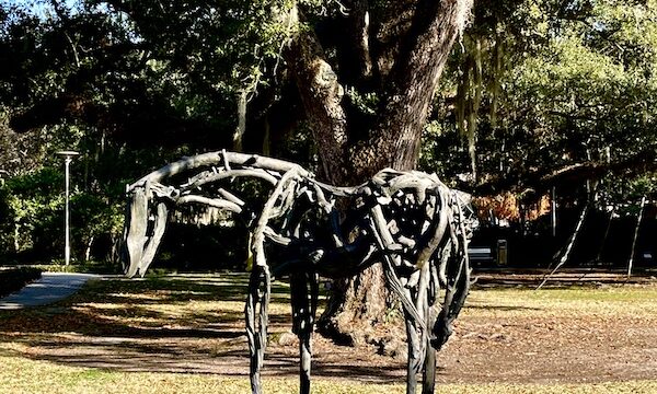 Stylized bronze statue of a horse with sunlight shining on it seen while Sharing Sculpture Garden with Friends