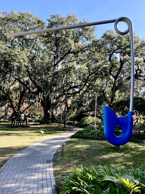 Enormous diaper pin with blue clasp spans the pathway through the sculpture gardens.