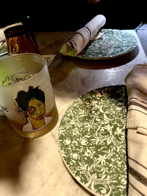 Hand painted glass on table along with plates, cloth napkins and glassware at The Columns New Orleans