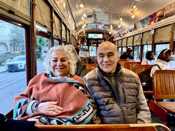 Steve and I sitting inside a New Orleans streetcar with wood interior on our way to The Columns