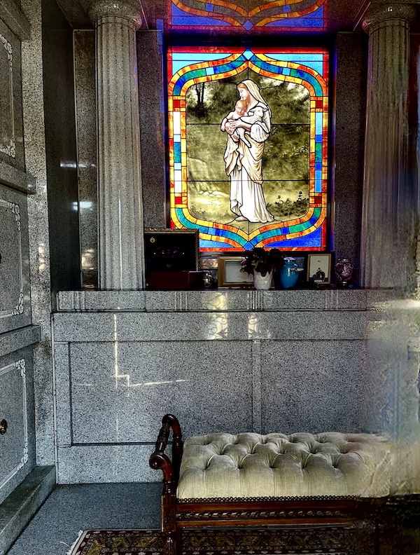 Beautiful stained glass window inside a mausoleum depicting the Madonna and child at Historic Metairie Cemetery Louisiana