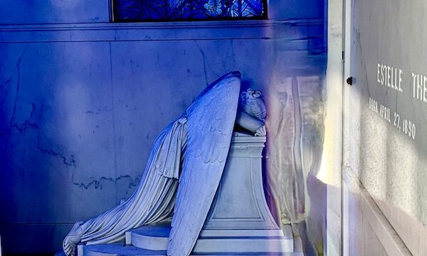 Statue of a weeping angel inside a mausoleum at Historic Metairie Cemetery Louisiana
