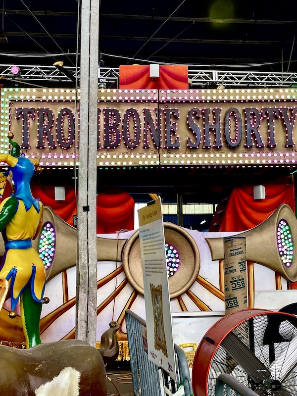 Float that looks like a riverboat with trombone player on bow at Mardi Gras World NOLA
