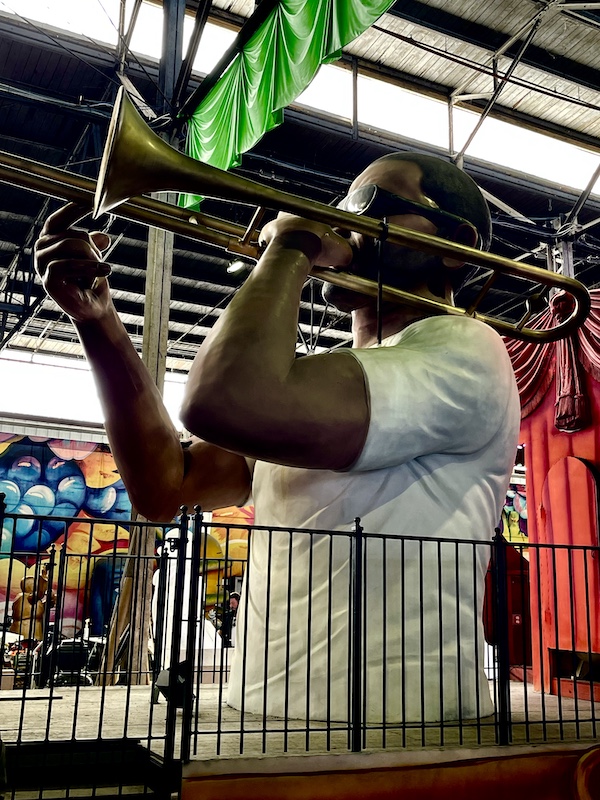 Trombone player sculpture on the bow of a riverboat float at Mardi Gras World NOLA