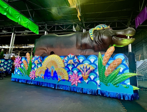 Float with giant hippo atop and colorful skirt hiding the wheels at Mardi Gras World NOLA