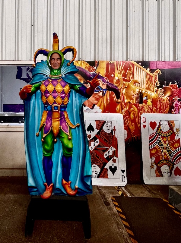 Steve as a giant Mardi Gras jester by float with playing cards at Mardi Gras World NOLA