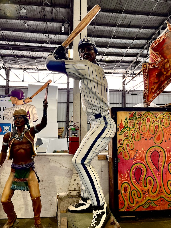 Baseball player float statue with bat in Yankees uniform at Mardi Gras World NOLA