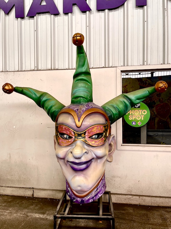 Float sculpture of a jester's giant head at Mardi Gras World NOLA
