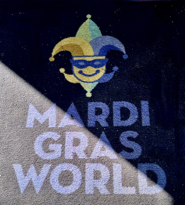 Welcome mat with a Green Gold and Purple jester at the entrance to Mardi Gras World NOLA