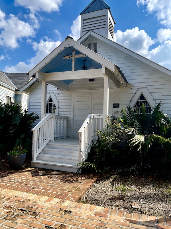 White clapboard church with steps and steeple at Le Vieux Village Opelousas LA