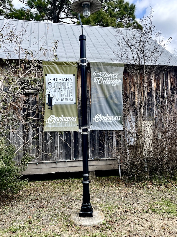 Two banner flags welcome you to Le Vieux Village Opelousas LA