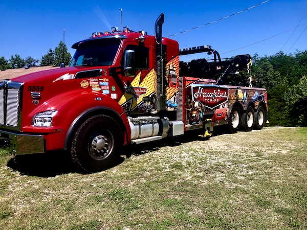 Huge red tow truck getting ready to tow us off our son's property.