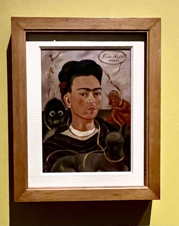Self portrait of Frida Kahlo with a small monkey in a wood frame with white fillet.