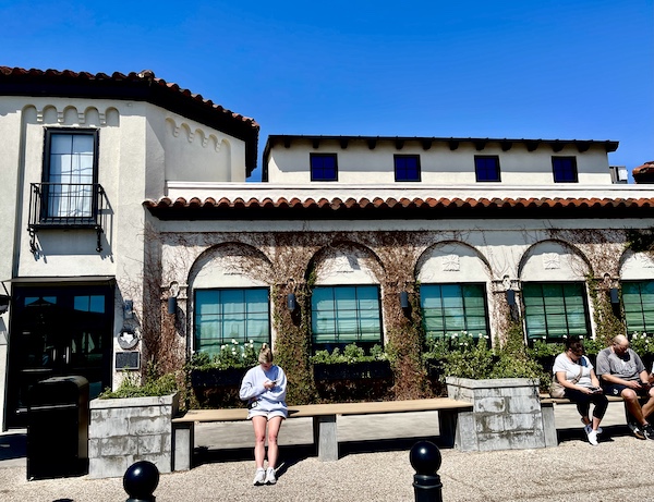 White stucco building with barrel tiled roof and arched windows is home of Magnolia Table Waco Texas