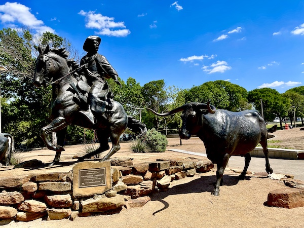 Cattle driver on horseback and Longhorn cattle form a group of bronze sculptures at Brazos Riverwalk Waco Texas