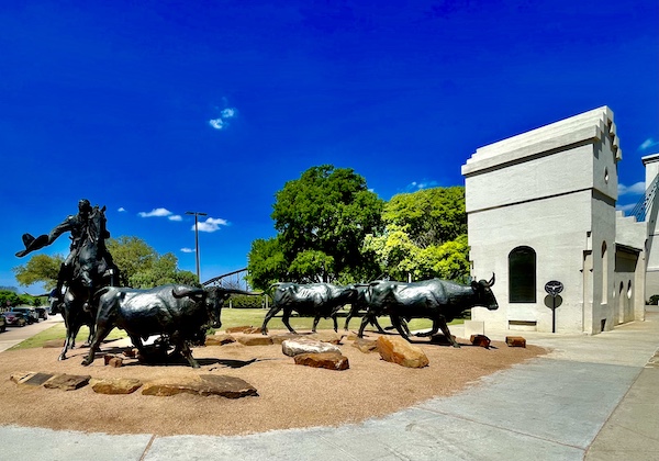Bronze sculptures of a trail boss on horseback and Longhorn cattle at Brazos Riverwalk Waco Texas