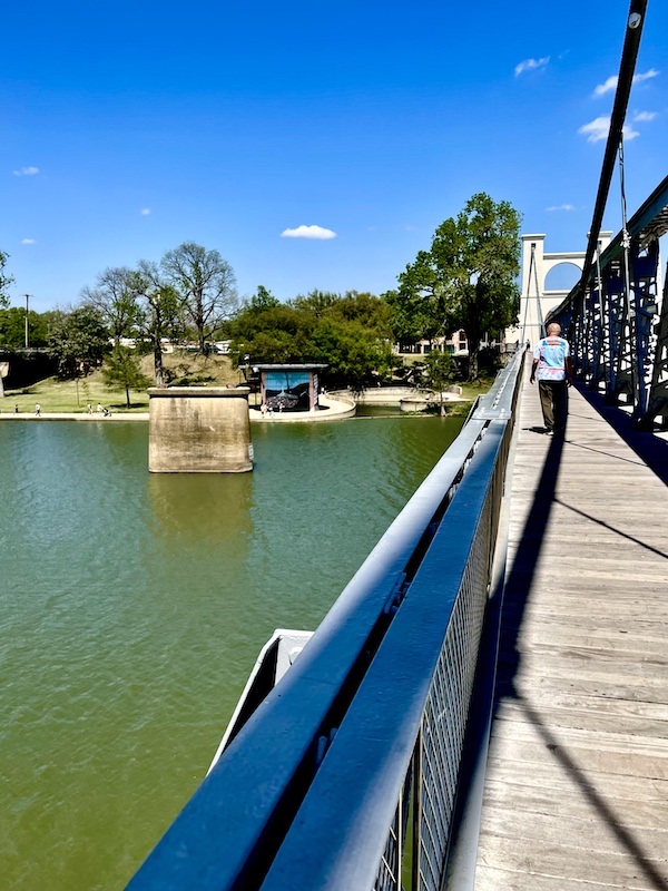 Steve seen from the rear as he crossed a river on a suspension bridge in Indian Springs Park Waco Texas