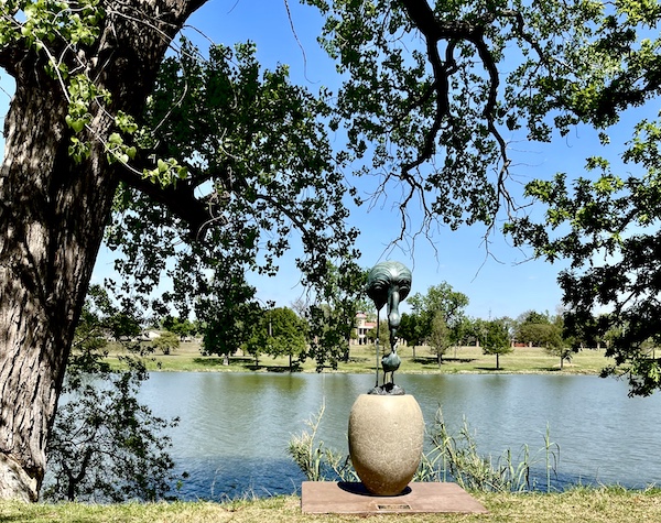 Verdigris sculpture of a mama flamingo feeding her baby at Indian Springs Park Waco Texas
