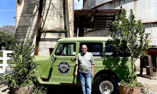 Steve standing beside a lime green Jeep-like vehicle between two trees at The Silos Waco Texas